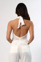 Back view of women's white chiffon halter top with keyhole detail and backless design.
