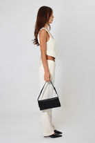 April Seven cropped backless vest and straight-leg pant set in white – minimalist tailored two-piece with clasp-back vest.