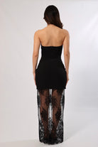 Back view of a woman in a strapless black maxi dress with a lace skirt, suitable for special occasions.