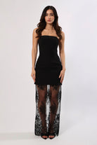 Woman in a strapless black maxi dress with a fitted bodice and long lace skirt.